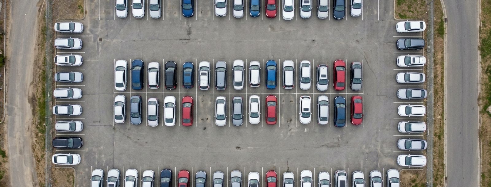 Luftaufnahme eines Stellplatzes mit vielen abgestellten Fahrzeugen